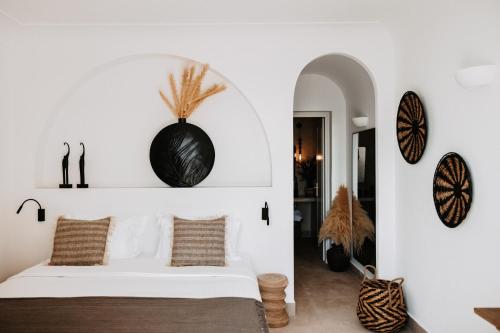 a bedroom with a bed and a wall with clocks at Le Cote Oia in Oia