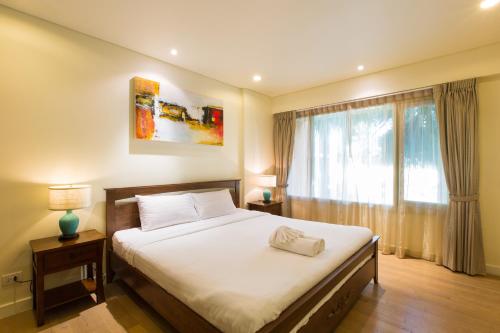 a bedroom with a large bed and a window at Mykonos Condo in Hua Hin