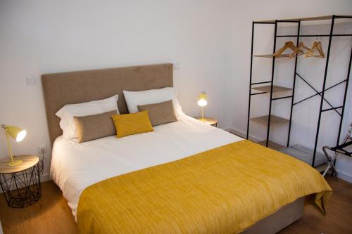 um quarto com uma cama grande e um cobertor amarelo em Prado 20 Twin em Vila Real