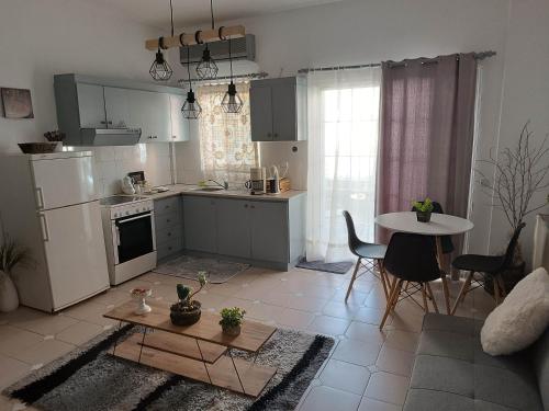 a kitchen and living room with a table and a kitchen and a dining room at Sofia-Marina Guest House in Xanthi