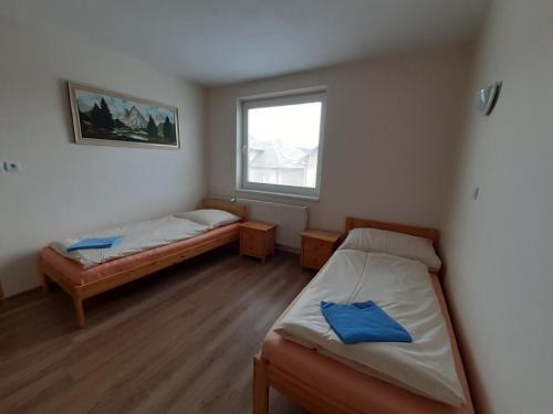 a room with two beds and a window at Turistická ubytovňa Hornád in Spišské Tomášovce