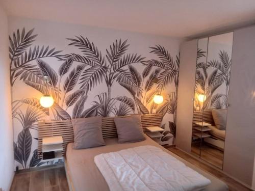 um quarto com um grande mural de palmeiras na parede em Superbe appartement piscine, tennis, vue mer et décoré avec goût em Cassis