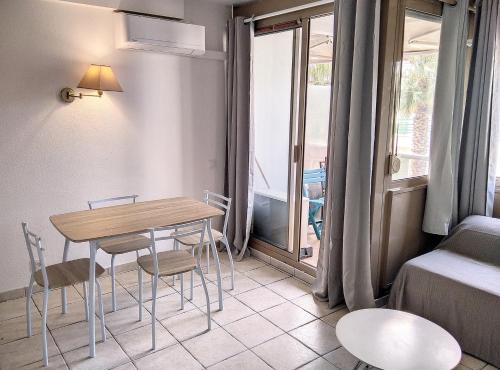 un salon avec une table et des chaises et un lit dans l'établissement Résidence Graziella Studio 501, à Juan-les-Pins