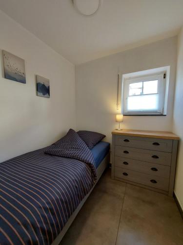 1 dormitorio con 1 cama y vestidor con ventana en a Bäckesch 17 en Nettersheim