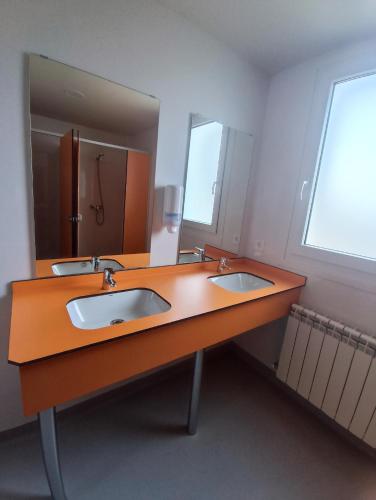 a bathroom with two sinks and a large mirror at La Rinconada in Castrojeriz