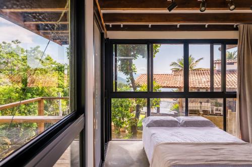 two beds in a room with a window at Casa Waimea in Ubatuba