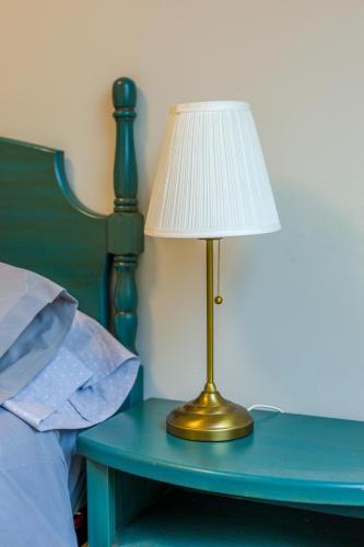 a lamp sitting on a table next to a bed at Casa Naseiro in Melide