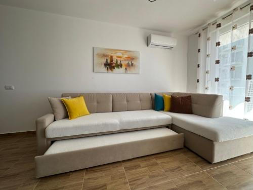 a living room with a brown couch and yellow pillows at Sea View Mario's Apartment in Sakës