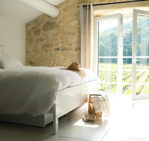 une chambre avec un lit et une grande fenêtre dans l'établissement le gîte de Montagnac, à La Roque-sur-Cèze
