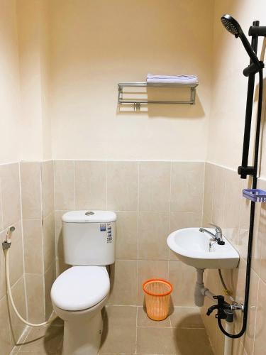 a bathroom with a toilet and a sink at IVI Hotel in Jakarta