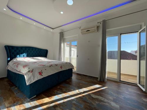 a bedroom with a bed and sliding glass doors at Apartmani centar ulcinj in Ulcinj