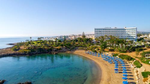 an aerial view of a beach with umbrellas and the ocean at Crystal Springs Beach Hotel in Protaras