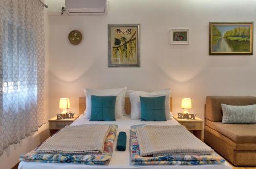 モスタルにあるVilla Acapulcoのベッド2台とソファが備わるホテルルームです。
