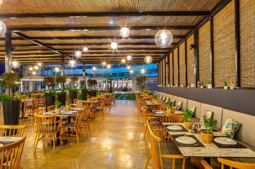 a restaurant with tables and chairs and a brick wall at Crystal Springs Beach Hotel in Protaras