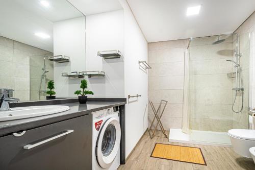 La salle de bains est pourvue d'un lavabo et d'un lave-linge. dans l'établissement BeGuest Aveiros Beach View Apartment, à Albufeira