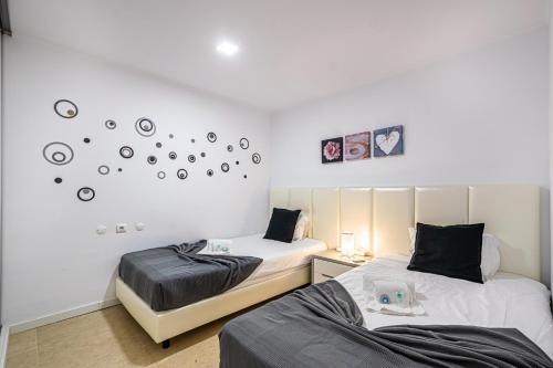 - 2 lits dans une chambre avec des horloges sur le mur dans l'établissement BeGuest Aveiros Beach View Apartment, à Albufeira