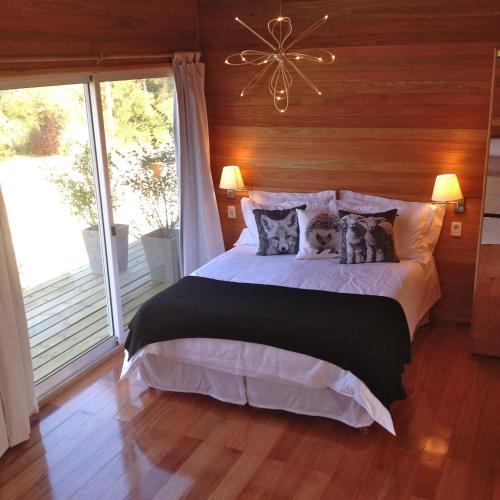 a bedroom with a bed with pillows and a window at Hjem Studios in La Pedrera