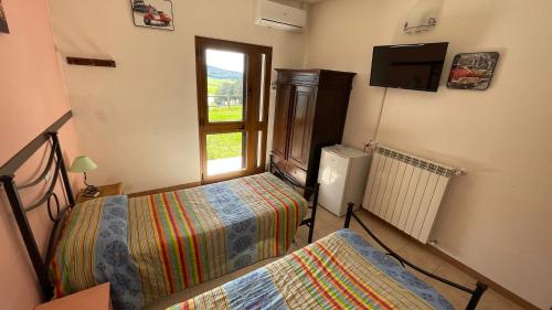 - une chambre avec 2 lits et une fenêtre dans l'établissement Agriturismo Da Pietro, à Pomarance