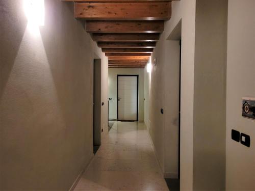 an empty hallway with white walls and a wooden ceiling at Borgo Antico Lake Endine Hospitality in Endine Gaiano