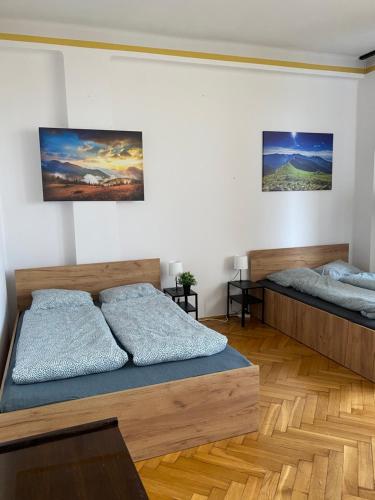 2 camas en una habitación con suelo de madera en Vintage Rooms in Old Town en Cracovia