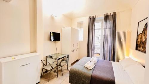 1 dormitorio con cama, mesa y ventana en Piccole suite di charme, en Turín
