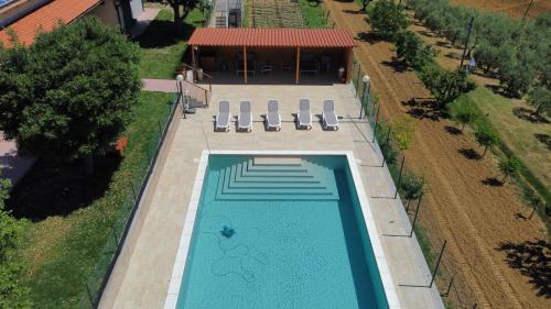 an overhead view of a swimming pool with chairs and a building at Agriturismo Da Pietro in Pomarance