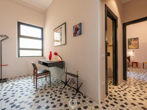 een kamer met een bureau, een stoel en een raam bij Harbor View Apartment in Cagliari