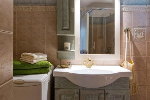 uma casa de banho com um lavatório branco e um espelho. em Casa Paleopolis em Corfu Town