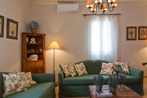 ein Wohnzimmer mit einer grünen Couch und einem Tisch in der Unterkunft Casa Paleopolis in Korfu-Stadt