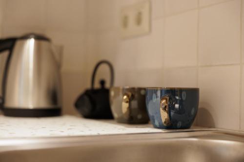 a kitchen counter with two coffee cups and a sink at Mon Repos Maison in Corfu Town