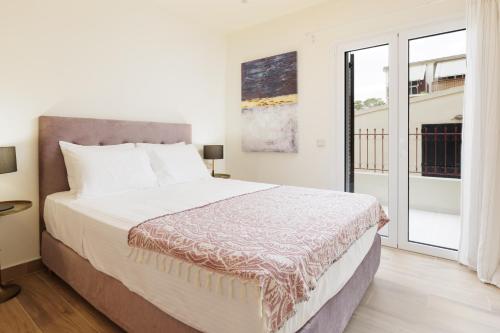 a bedroom with a bed and a large window at Mon Repos Maison in Corfu Town