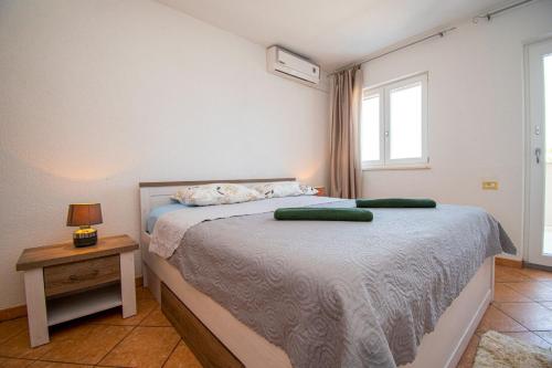 ein Schlafzimmer mit einem Bett mit zwei grünen Kissen darauf in der Unterkunft House Suzana in Banjole