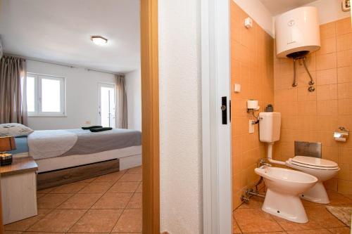 ein Bad mit einem Bett und einem WC in einem Zimmer in der Unterkunft House Suzana in Banjole
