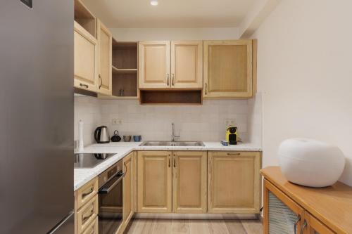 a kitchen with wooden cabinets and a sink at Mon Repos Maison in Corfu Town