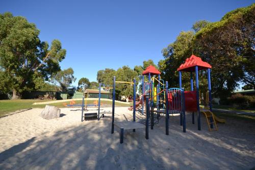 a playground with colorful equipment in a park at Albany Holiday Park in Albany