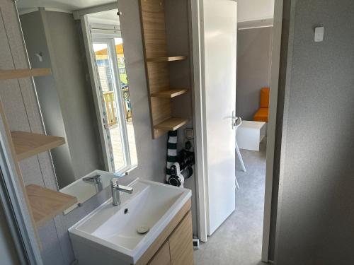 a bathroom with a sink and a mirror at mobil home 6 places tout confort in Saint-Georges-de-Didonne