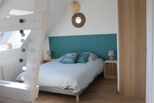 sypialnia z białym łóżkiem i niebieską ścianą w obiekcie "Le 104" studio cosy proche de Rouen avec parking w mieście Mont-Saint-Aignan