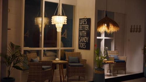 a room with chairs and a table and chandeliers at The White Bay in Gili Trawangan
