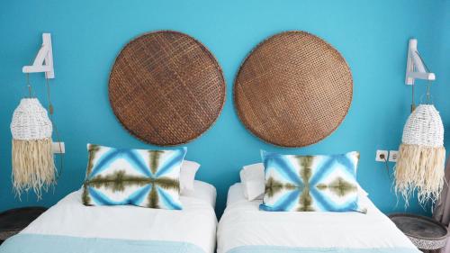 a room with two beds and a blue wall at The White Bay in Gili Trawangan