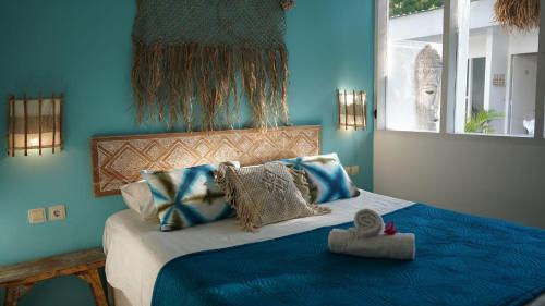 a blue bedroom with a bed with blue walls at The White Bay in Gili Trawangan