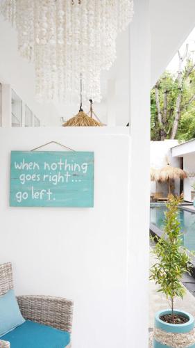 a sign that is on a wall in a room at The White Bay in Gili Trawangan