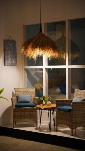 a room with wicker chairs and a table and a window at The White Bay in Gili Trawangan