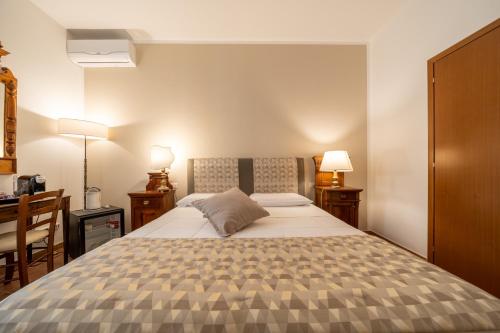 a bedroom with a bed and two lamps and a desk at Affittacamere Valentina in Orvieto