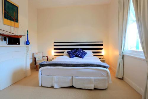 a bedroom with a bed with a blue pillow on it at @ the beach & not quite @ the beach Holiday Cottages - Stanley in Stanley