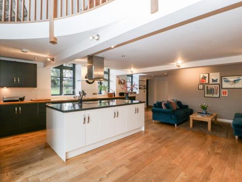 an open living room with a kitchen and a living room at Owl Barn in Leominster