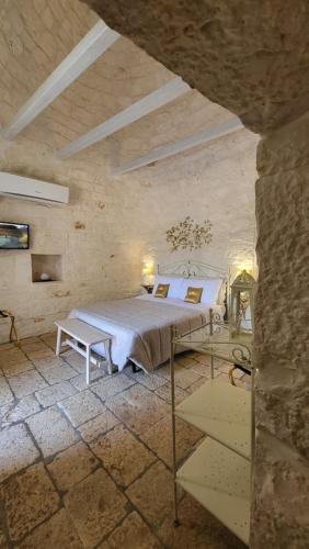 a bedroom with a bed in a stone wall at Casa Relax Isabelle in Alberobello