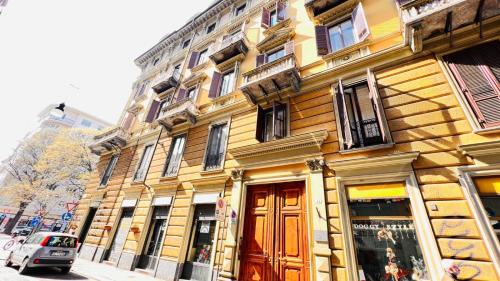 un edificio amarillo con una puerta roja en una calle en Piccole suite di charme en Turín