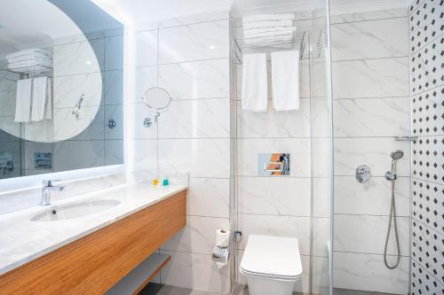 a bathroom with a shower and a toilet and a sink at The Sansa Hotel & Spa in Manavgat
