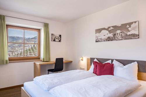 Cornedo all'IsarcoにあるApartments Gojer Sauvignonのベッドと窓のあるホテルの部屋