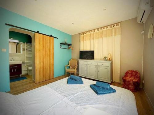 - une chambre avec un lit et 2 serviettes bleues dans l'établissement Sasha'blue-terrasse jardin-park-clim-piscine, à LʼIsle-sur-la-Sorgue